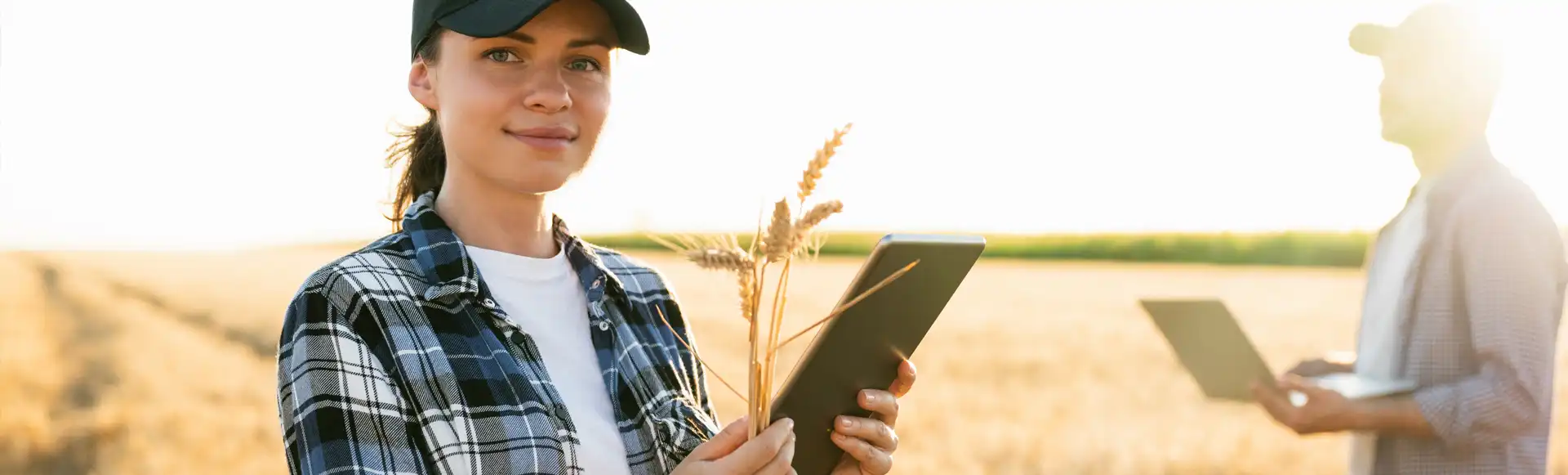 Hombre y mujer agricultores usando CUE en tablet y portátil